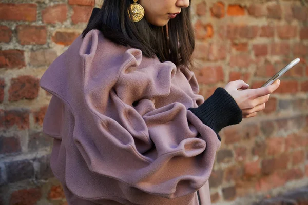 Жінка з фігурами, що дивляться на смартфон перед показом моди Сальваторе Феррагамо, Міланський стиль Тижня моди — стокове фото