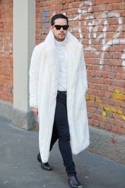 Fendi moda defilesinden önce beyaz kürklü ve balıkçı yakalı bir adam, Milan Moda Haftası tarzı.