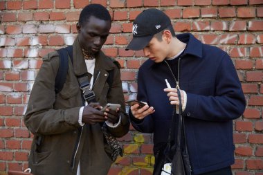 Top modeller Fendi defilesinden sonra akıllı telefonlara bakıyorlar, Milan Moda Haftası tarzı.