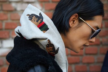 Fendi defilesinden önce el tasarımlı gri kapüşonlu top model, Milan Moda Haftası tarzı.