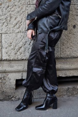 Yüksek topuklu ayakkabılı ve siyah saten pantolonlu bir adam. Reshake defilesinden önce, Milan Moda Haftası tarzı.