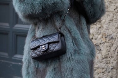 Reshake defilesinden önce siyah Chanel deri ve kürklü kadın, Milan Moda Haftası tarzı.