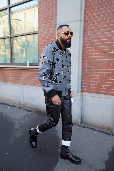 Tasarımları ve siyah deri pantolonu olan gri ceketli adam Fendi moda defilesinden önce yürüyor, Milan Moda Haftası tarzı. — Stok fotoğraf