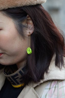 Yeşil sarı küpeli ve Fendi tişörtlü kadın Reshake defilesinden önce, Milan Moda Haftası tarzı