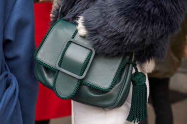 Marco de Vincenzo moda defilesinden önce yeşil deri çantalı ve gri kürklü kadın, Milan Moda Haftası tarzı.