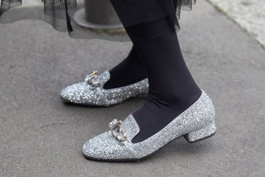 Marco de Vincenzo moda defilesinden önce gümüş parıltılı ve mücevherli kadın, Milan Moda Haftası tarzı.