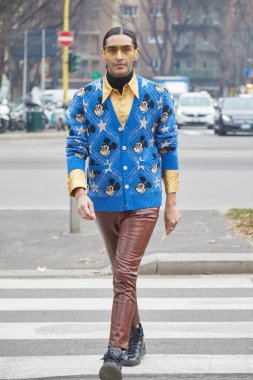 Gucci moda defilesinden önce üzerinde Mickey Mouse olan sarı gömlekli ve mavi kazaklı adam, Milan Moda Haftası tarzı.