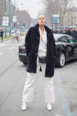 Gucci moda defilesinden önce siyah kürklü, beyaz gömlekli ve pantolonlu kadın, Milan Moda Haftası tarzı.
