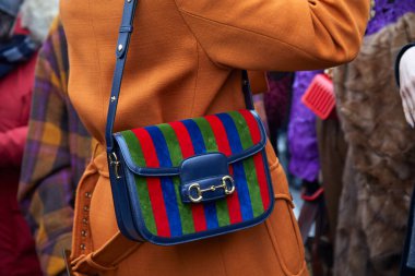 Gucci moda defilesinden önce yeşil, kırmızı ve mavi çizgili Gucci çantalı kadın, Milan Moda Haftası tarzı.