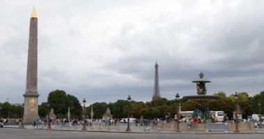 Obelisk ve Eyfel Kulesi manzaralı Concorde Meydanı Paris 'te bulutlu bir yaz gününde insanlarla