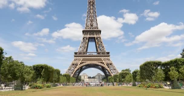 Torre Eiffel em Paris e campo verde de Marte prado, pessoas e turistas em um dia ensolarado de verão, céu azul — Vídeo de Stock