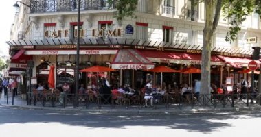 Paris, Fransa 'da güneşli bir yaz gününde, insanların ve turistlerin oturduğu kaldırım masalı tipik kafe brasserisi.