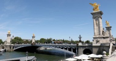 Alexandre III, güneşli bir yaz gününde Paris, Fransa 'da mavi gökyüzü üzerinden geçen insanlarla ve turistik otobüslerle dolu bir köprü..