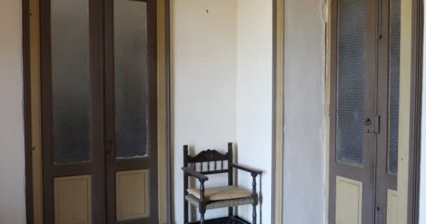 Mujer con vestido blanco pasando en habitación de la casa vieja, puerta de cristal — Vídeo de stock