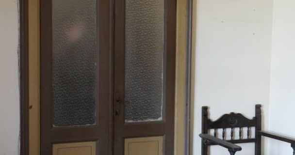 손이 나타나서 오래 된 집 유리 문으로 사라진다 — 비디오