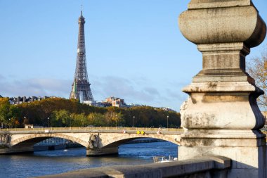 Eyfel Kulesi, Paris, Fransa 'da güneşli bir günde Seine nehri ve sütunuyla köprü