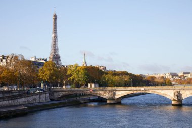 Paris, Fransa 'da güneşli bir günde Eyfel Kulesi, köprü ve Seine nehri manzaralı sonbahar ağaçları