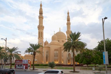DUBAI, BİRLİK ARAB EMIRATES - 21 Kasım 2019: Öğlen vakti palmiye ağaçları ve sokak manzaralı Jumeirah camisi
