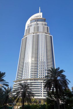 DUBAI, BİRLİK ARAB EMIRATES - 22 Kasım 2019: Güneşli bir günde şehir merkezindeki lüks otel, açık mavi gökyüzü