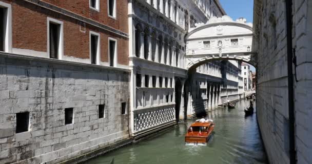 Мост Вздохов, людей и туристов на гондоле и деревянной моторной лодке с видом на знаменитый мост в солнечный летний день в Венеции, Италия — стоковое видео