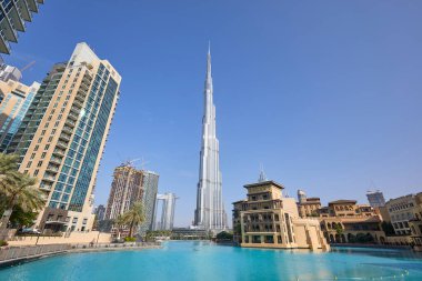 Dubai, Birleşik Arap Emirlikleri - 19 Kasım 2019: Burj Halife gökdeleni, yapay göl ve güneşli bir günde modern binalar 
