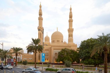 Dubai, BİRLİK ARAB EMIRATES - 21 Kasım 2019: Palmiye ağaçları ve öğleden sonra yoldan geçen insanlarla dolu Jumeirah camii manzarası
