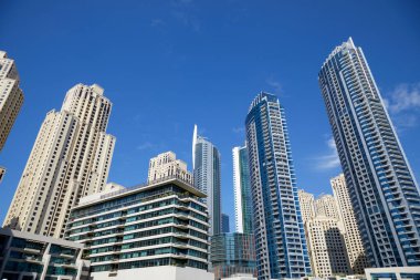 Dubai Marina gökdelenleri, güneşli bir günde alçak açı, Dubai 'de açık mavi gökyüzü