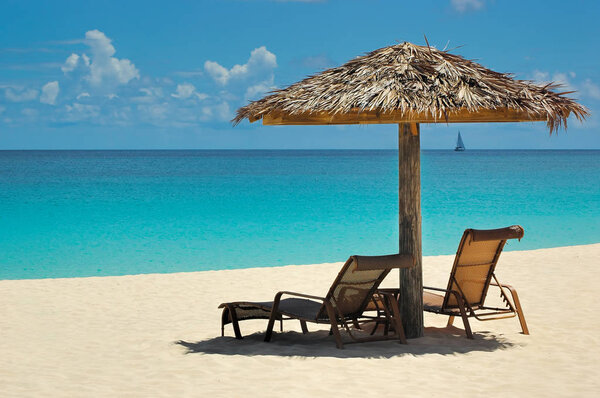 Very relaxing tranquil Caribbean view with a thatch umbrella and chaise lounge