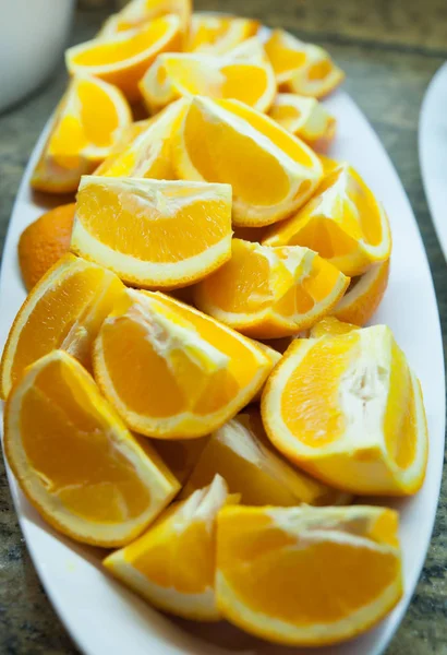 Freshly cut oranges on a plate at the breakfast bar