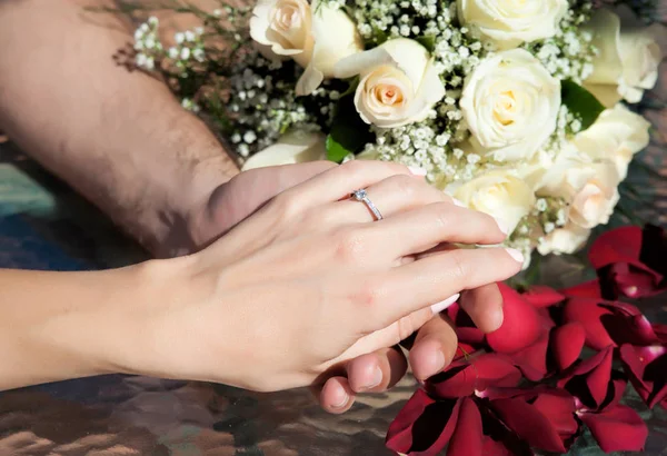 Manos de novia y novio con anillo de compromiso y arreglo floral —  Fotos de Stock