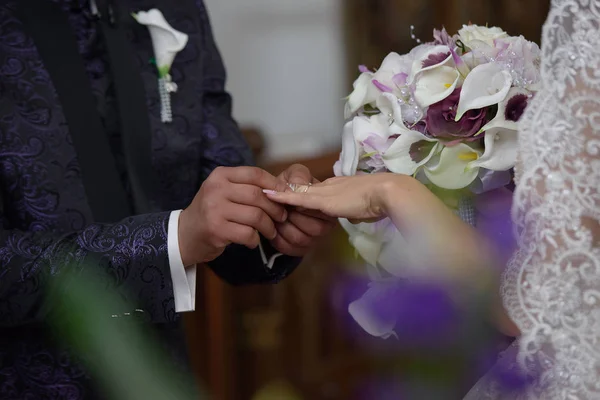 Close-up do noivo segurando o dedo da noiva para o anel de casamento — Fotografia de Stock