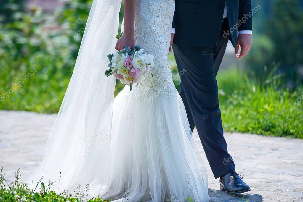 Cropped shot of Caucasian bride and groom walking together