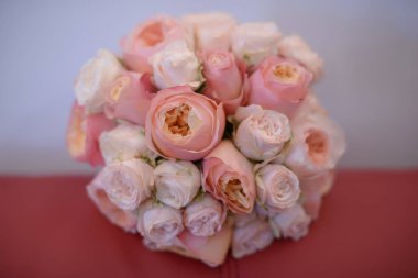 Gölgeli ve mercan pembe peonies, çiçek düzenleme bir deri yastık ve arka plan bulanık ayarla