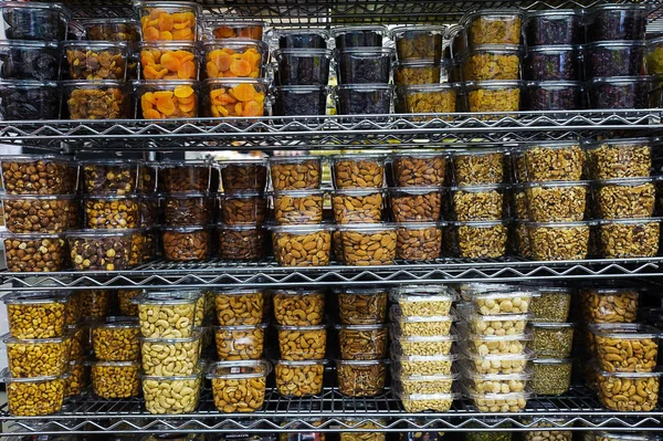Çeşitli kurutulmuş meyve ve fındık kolaylık ve tazelik, metal raf veya süpermarkette raf üzerinde konumlandırılmış için hava geçirmez şeffaf plastik kaplarda paketlenmiş yığını 