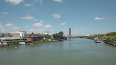 Seville, Endülüs, İspanya - 26 Haziran 2019: Guadalquivir nehri üzerindeki Puente San Telmo köprüsünden Torre del Oro, Triana köprüsü ve mahallesi ve Cajasol Kulesi 'ne kadar şehrin manzarası