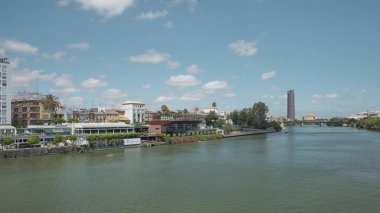 Seville, Endülüs, İspanya - 26 Haziran 2019: Guadalquivir nehri üzerindeki Puente San Telmo köprüsünden Torre del Oro, Triana köprüsü ve mahallesi ve Cajasol Kulesi 'ne kadar şehrin manzarası