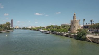Seville, Endülüs, İspanya - 26 Haziran 2019: Guadalquivir nehri üzerindeki Puente San Telmo köprüsünden Torre del Oro, Triana köprüsü ve mahallesi ve Cajasol Kulesi 'ne kadar şehrin manzarası