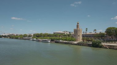 Seville, Endülüs, İspanya - 26 Haziran 2019: Guadalquivir nehri üzerindeki Puente San Telmo köprüsünden Torre del Oro, Triana köprüsü ve mahallesi ve Cajasol Kulesi 'ne kadar şehrin manzarası