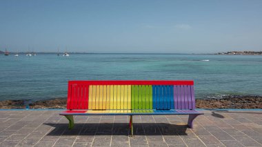 Corralejo 'da iç kısımlara bakan gökkuşağı bankı, oturma ya da dinlenme alanı renkleri, Lgbt toplumunun sembolü ya da Fuerteventura, Kanarya Adaları, İspanya' da kabul ve kapsayıcılık kavramları.