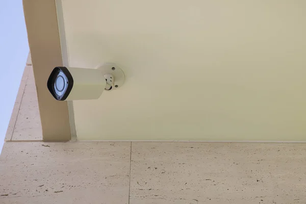 Sokak gözetlemesi, sokakları, evleri veya ofisleri izleme, güvenlik sistemleri konsepti ve kamu güvenliği veya kamu güvenliği veya mahremiyet ihlali için bir bina duvarına veya tavana monte edilmiş modern CCTV kamerası