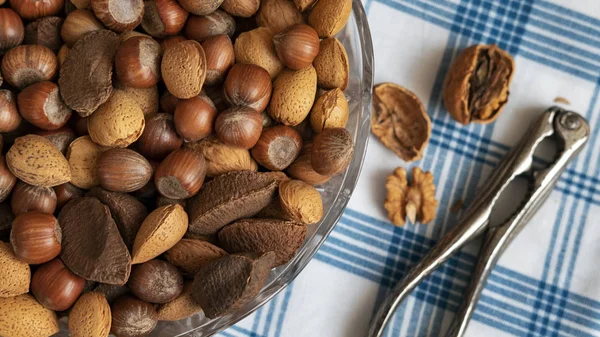 Assortment of whole nuts, walnuts, almonds, hazelnuts and Brazil nuts with nut cracker. Hard shell nuts, nutritious snack cracked and eaten in autumn or winter months as a special holidays treat.