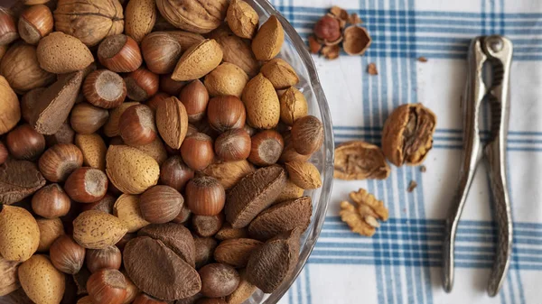 Assortment of whole nuts, walnuts, almonds, hazelnuts and Brazil nuts with nut cracker. Hard shell nuts, nutritious snack cracked and eaten in autumn or winter months as a special holidays treat.