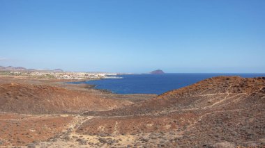Montana Amarilla Zirvesi 'ni çevreleyen kurak volkanik manzaranın yükseltilmiş manzarası Marina San Miguel, Atlantik Okyanusu ve Montana Roja, Costa del Silencio, Tenerife, Kanarya Adaları, İspanya