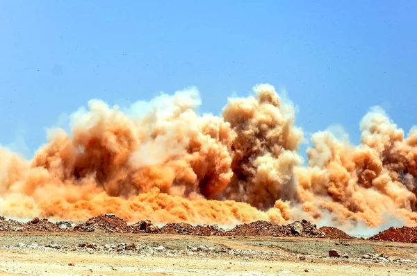 Dust clouds after detonator blast on the mining site