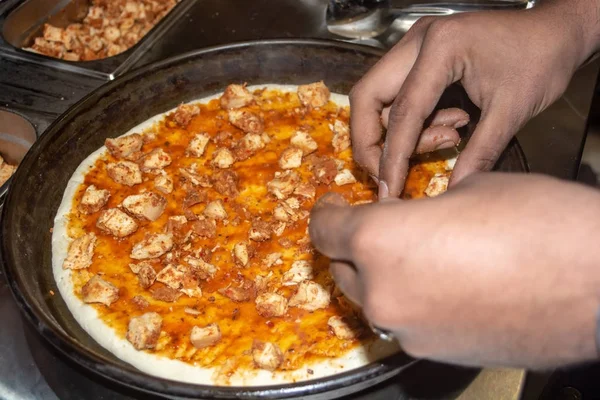 Worker is preparing pizza topping in the Colombo