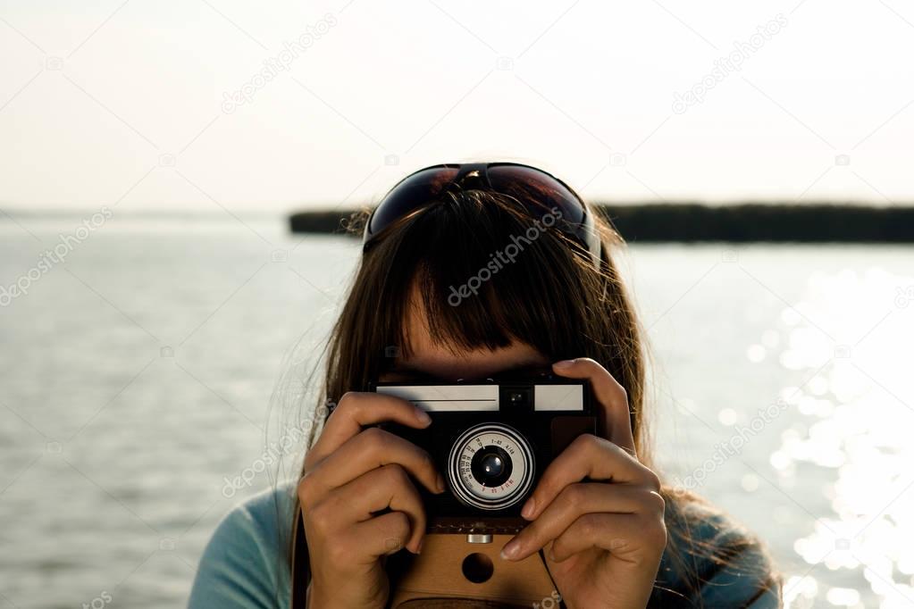 Girl taking photograph with old camera