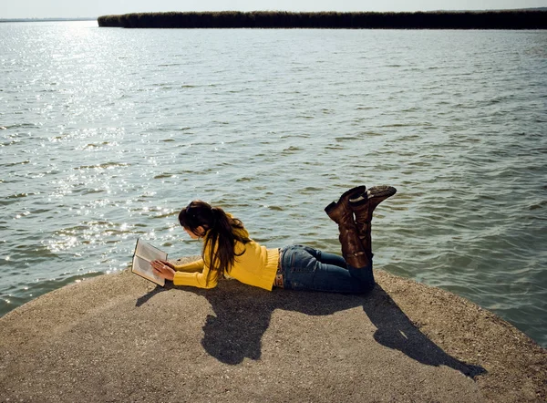 湖で横になっていると本を読む少女 — ストック写真