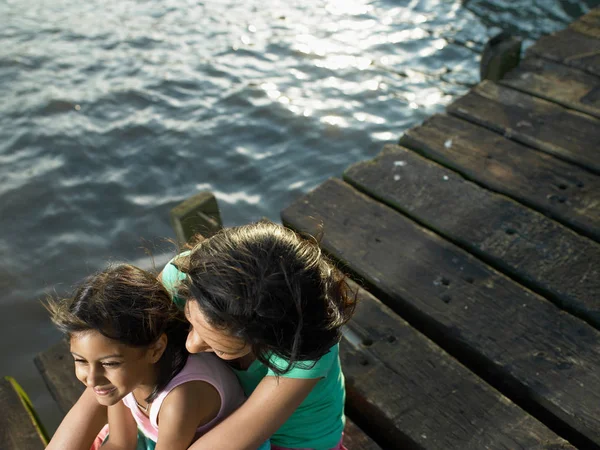 Madre e hija sentadas en el muelle — Foto de Stock