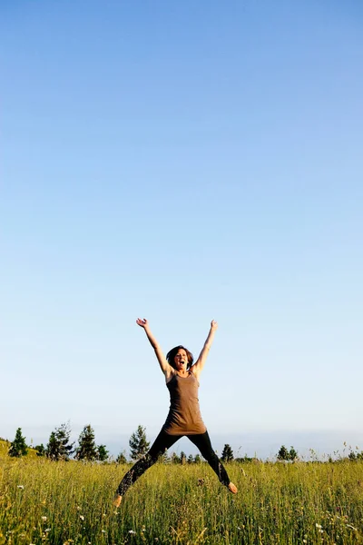 Mujer saltando en el campo — Foto de Stock