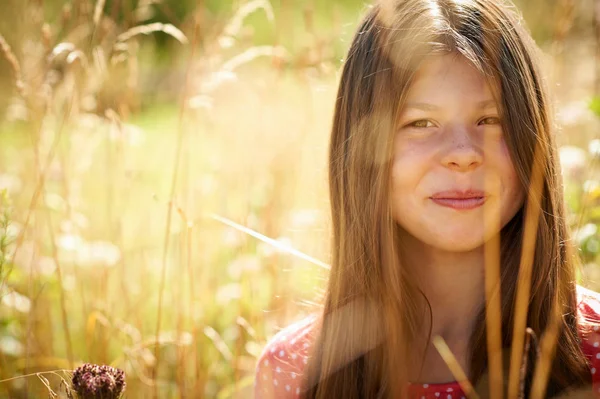 Dospívající dívka s úsměvem ve vysoké trávě — Stock fotografie